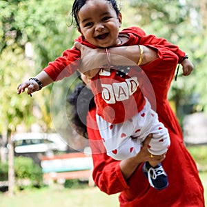 Loving mom carrying of her baby at society park. Bright portrait of happy mum holding child in her hands. Mother hugging her