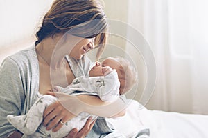 Loving mom carying of her newborn baby at home