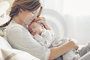 Loving mom carying of her newborn baby at home