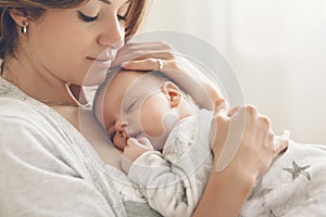 Loving mom carying of her newborn baby at home