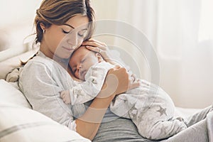 Loving mom carying of her newborn baby at home