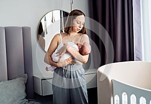 Loving mom carying of her newborn baby at home.