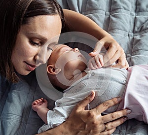 Loving mom carying of her newborn baby at home.