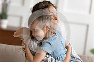 Loving mom hug little daughter gives her tenderness and love