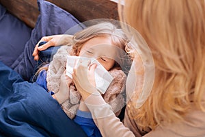 Loving mother blowing her daughters nose