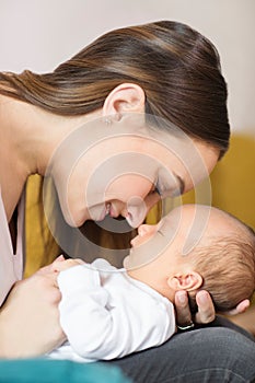 Loving Mother Cuddling Baby Son And Touching Noses