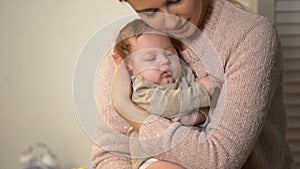 Loving mother cuddling little baby tenderly, newborn healthcare and patronage