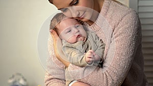 Loving mother cuddling little baby tenderly, newborn healthcare and patronage