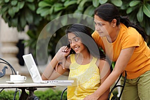 Loving mother and daughter with laptop outdoors