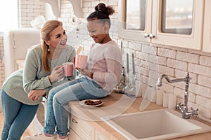 Loving mother feeling happy looking at her adopted daughter