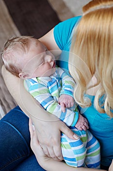 Loving mother hand holding cute sleeping newborn baby child