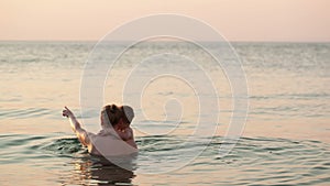 Loving mother and her child bathing in the sea