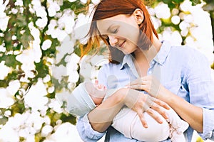 Loving mother with her newborn baby on her arms.