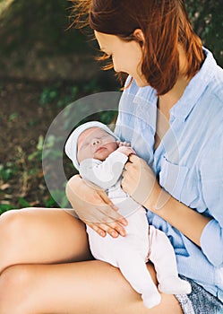 Loving mother with her newborn baby on her arms.