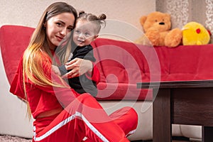 Loving mother hugging her happy little daughter