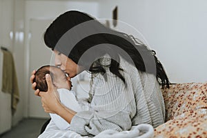 Loving mother kissing her infant baby