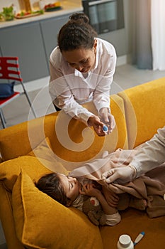 Loving mother staring at her daughter, sick with cold