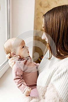 Young mother with her newborn baby at home. Happy family concept.