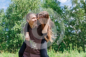 Loving multilingual couple on a walk in the Park. In love and very cheerful couple. Girl riding a guy.