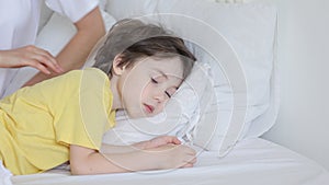 Loving mum check child forehead temperature caress and stroke little boy sleeping in comfortable bed