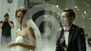 Loving newlywed couple dancing the first dance at wedding shrouded with confetti