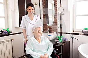 Loving nurse assisting nursing home occupant who is in wheelchair