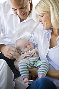 Loving parents holding baby sound asleep in arms