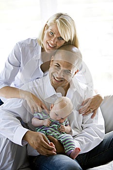 Loving parents with sleeping baby in dad's lap