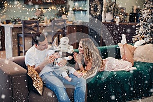 Loving parents spending time with baby on winter holidays