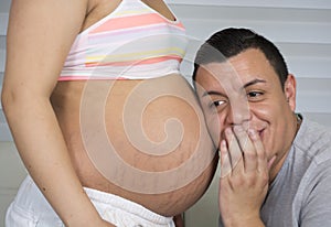 Loving pregnant couple hugging the belly