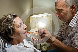 Loving retired husband feeding his ill wife photo