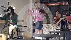 Loving retro couple dancing in coffee bar with people drinking coffee at tables. Positive Caucasian redhead man and