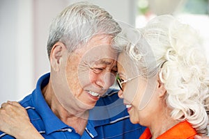 Loving Senior Chinese Couple Together At Home