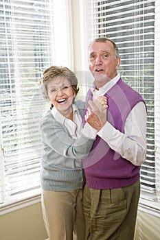 Loving senior couple dancing in living room
