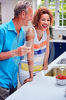 Loving Senior Couple On Summer Vacation Drinking Wine In Holiday Apartment