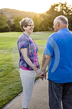 A loving senior couple on a walk together at sunset