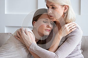 Loving senior mother hug adult daughter showing support