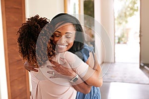 Loving Senior Mother Hugging Adult Daughter Indoors At Home