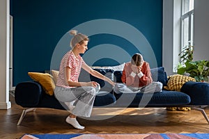 Loving supportive mother comforting upset crying teen daughter while sitting together on sofa