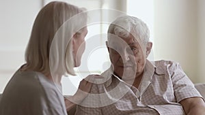 Loving understanding mature wife or caregiver listening to senior husband