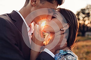 Loving wedding couple kissing in mountains at sunset. Portrait of bride and groom in summer Carpathians. Valentine`s day