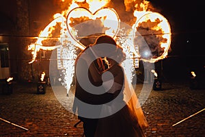 Loving wedding couple kissing and watching fire-show