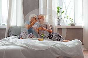 Loving wife feeding her husband with porridge using a spoon
