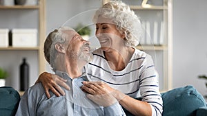 Loving wife hugs beloved grey-haired husband from behind