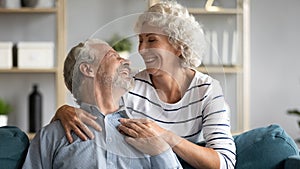 Loving wife hugs beloved grey-haired husband from behind photo