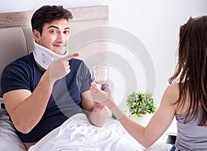 Loving wife taking care of injured husband in bed