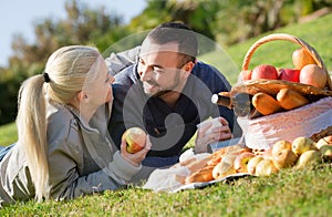 Loving young beautiful couple chatting as having picnic