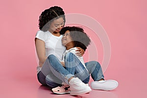 Loving Young Black Mom Tenderly Hugging Her Adorable Little Daughter