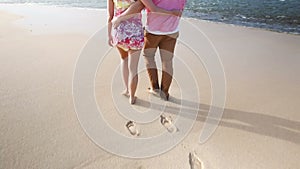 Loving young Caucasian couple holding hands walking together beach Oahu Hawaii