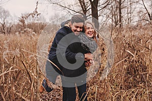 Loving young couple happy together outdoor on cozy warm walk in autumn forest photo